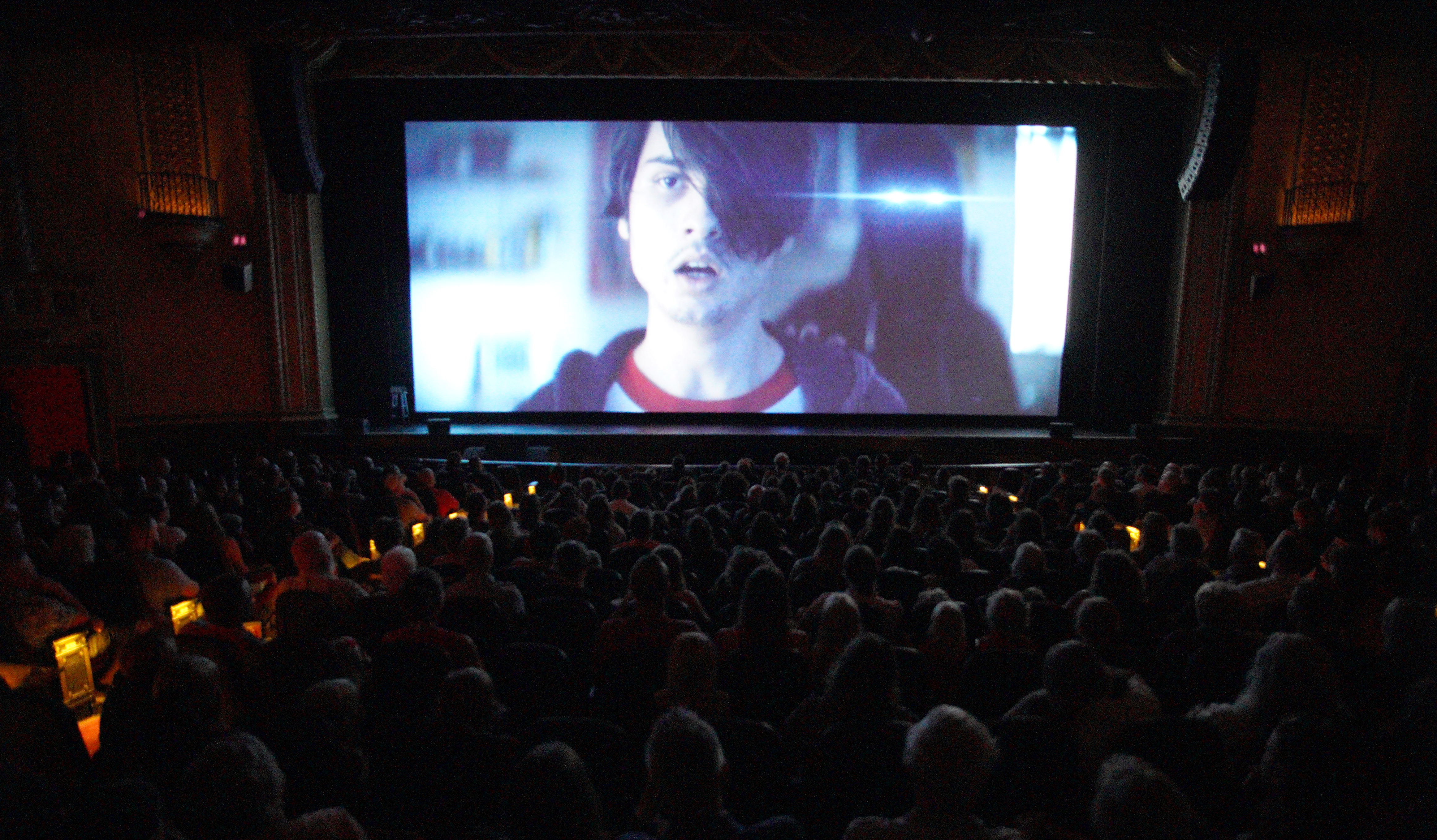People watching a bright movie screen