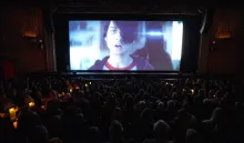 People watching a bright movie screen